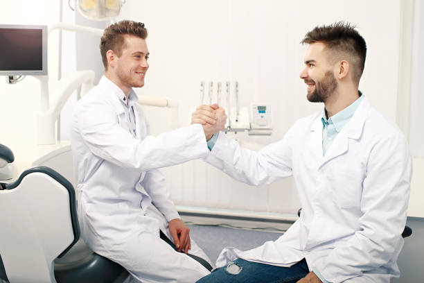 istock Two male doctors handshaking in the dentist office 938733770