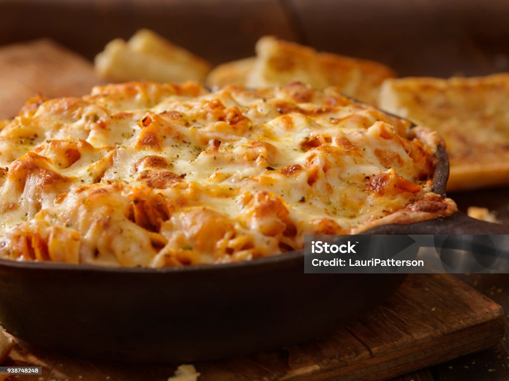Cheesy Baked Rotini Pasta in Roasted Tomato and Garlic Sauce with Garlic Bread Cheese Stock Photo