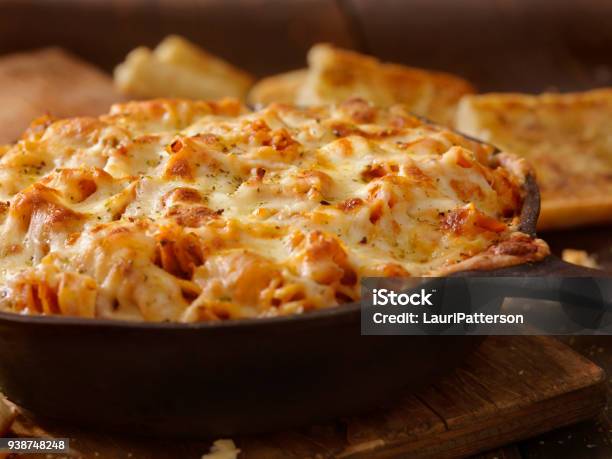 Cheesy Baked Rotini Pasta In Roasted Tomato And Garlic Sauce With Garlic Bread Stock Photo - Download Image Now