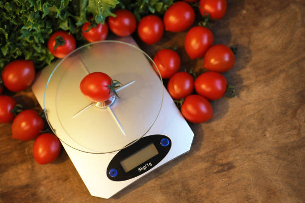 istock Fresh tomatoes on kitchen scales weighing 938770492