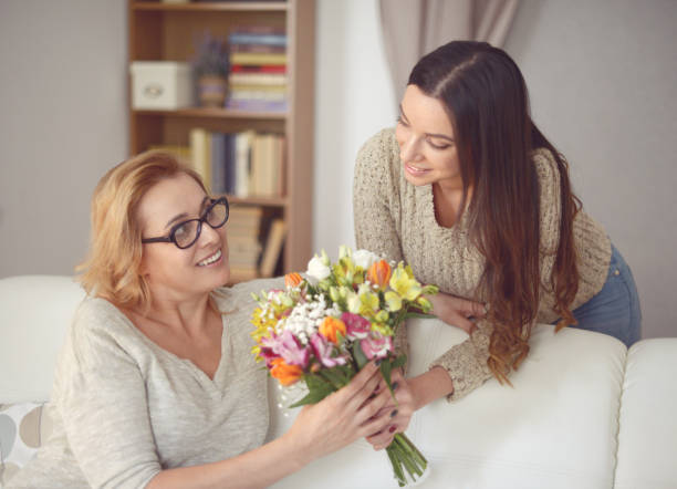 istock Mom and daughter with flowers 938771614