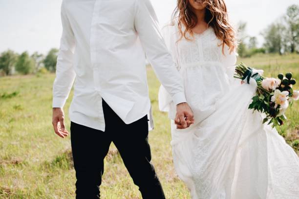 istock Midsection Of Couple With Holding Hands Walking On Field 938778204