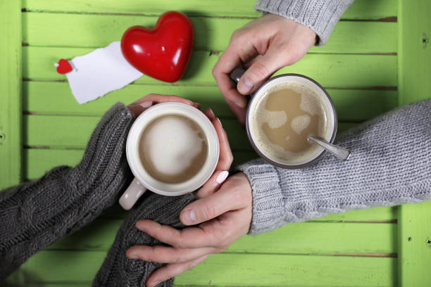 istock Young couple drinking hot coffee at wooden table on a date 938778240