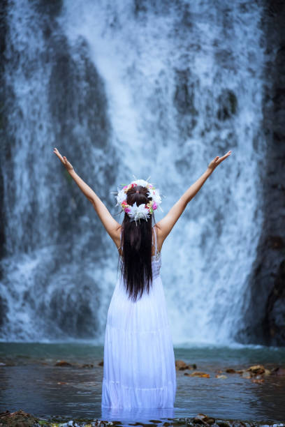 istock Rear View Of Woman Standing Against Waterfall 938779328