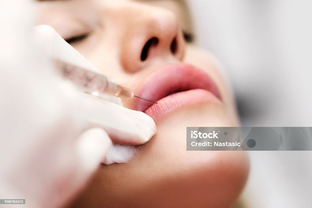 Professional cosmetologist injecting silicone in lips Professional cosmetologist making facial injection Botulinum Toxin Injection Stock Photo