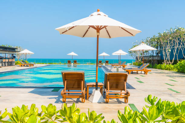 istock Lounge Chairs With Parasol By Swimming Pool Against Clear Sky 938782668