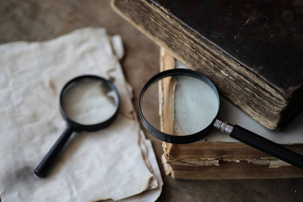 istock Old books on a wooden table and magnifier 938785476