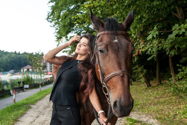 Pretty young woman and a brown horse stock photo
