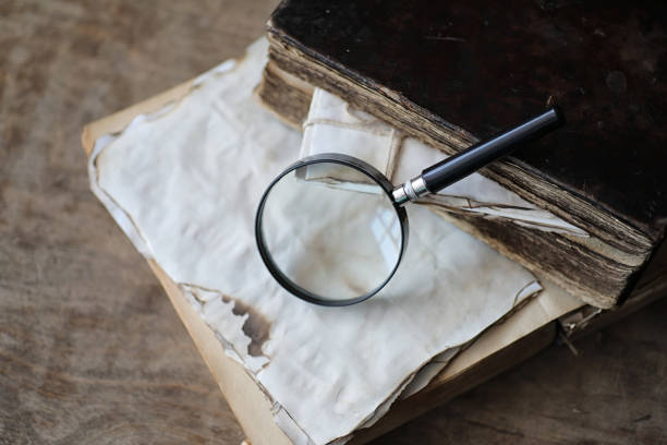 istock Old books on a wooden table and magnifier 938786024
