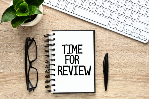 istock Words time for review on ring-bound notebook with glasses, green plant and keyboard 938787620