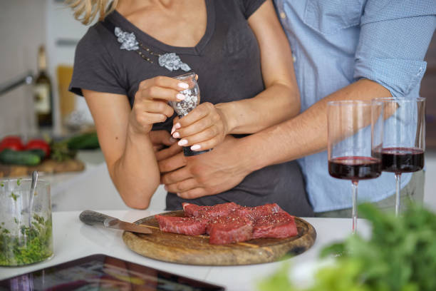 Couple Cooking meat together.  Hobby Lifestyle Concept stock photo