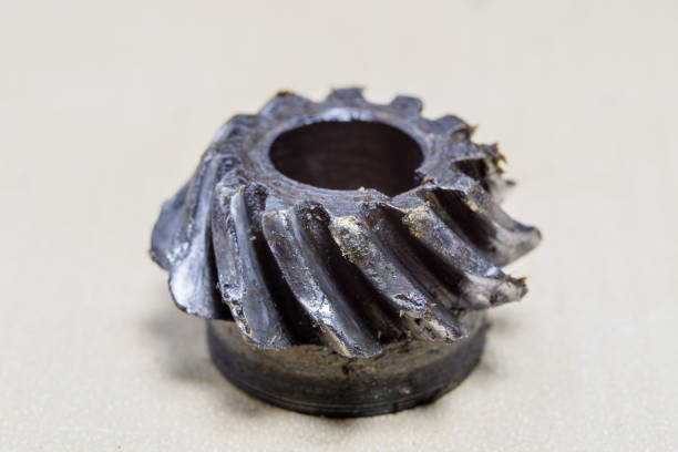 Old worn out gears in an angular gear. Mechanical accessories designed for regeneration in a repair shop. Black background.
