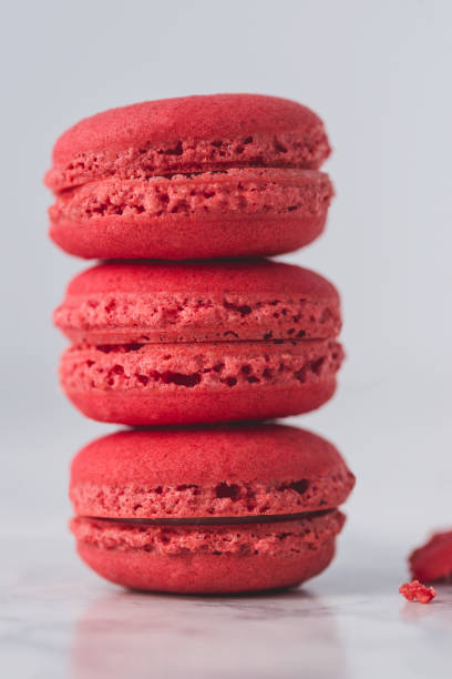 istock Red macarons arranged one over another on white marble background. Close up. 938827972