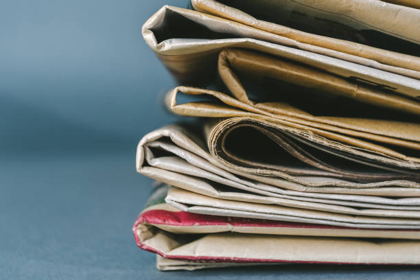 istock Close-Up Of Newspapers On Table 938831208