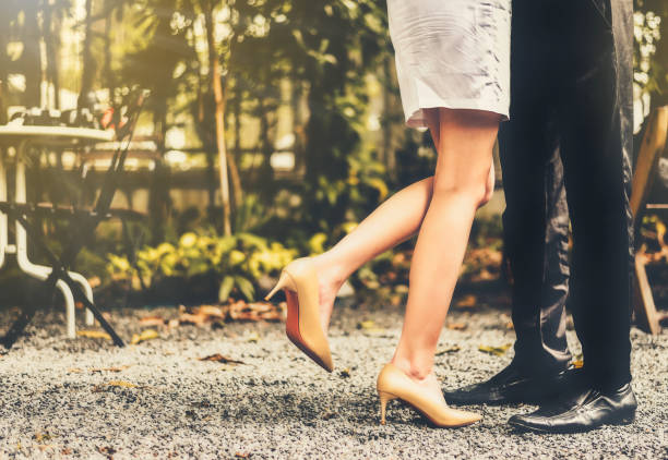 istock Low Section Of Couple Standing On Road 938843486