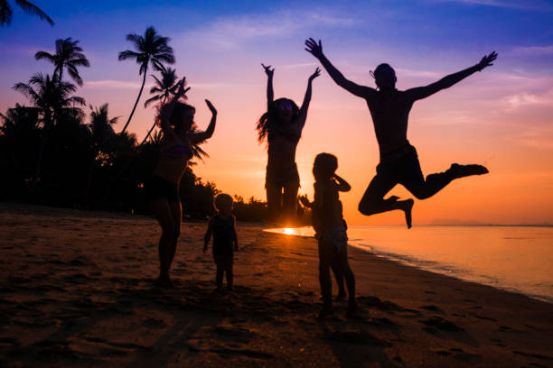 friends dancing on a sunset beach Crowd people friends sunset beach holidays sunset beach hawaii stock pictures, royalty-free photos & images