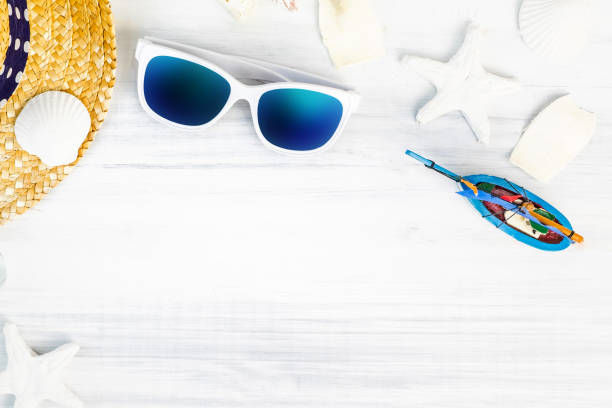 istock Summer Beach accessories (White sunglasses,starfish,straw hat,glass bottle,shell) on white plaster wood table top view,Summer vacation concept,Leave space for adding text 938849602