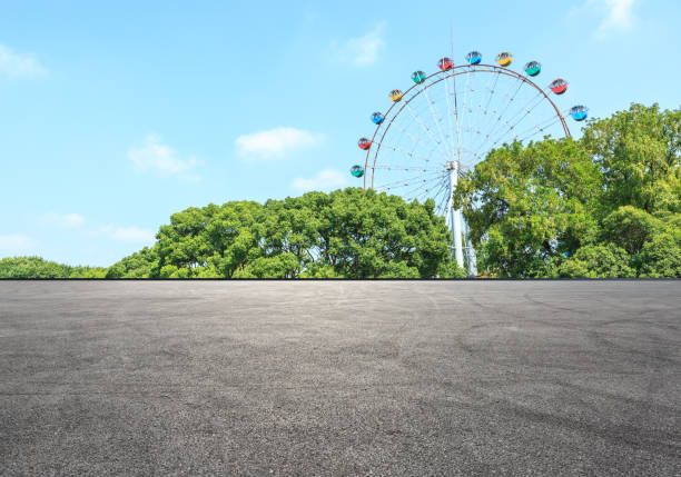 istock asphalt road and forest with playground ferris wheel 938867070