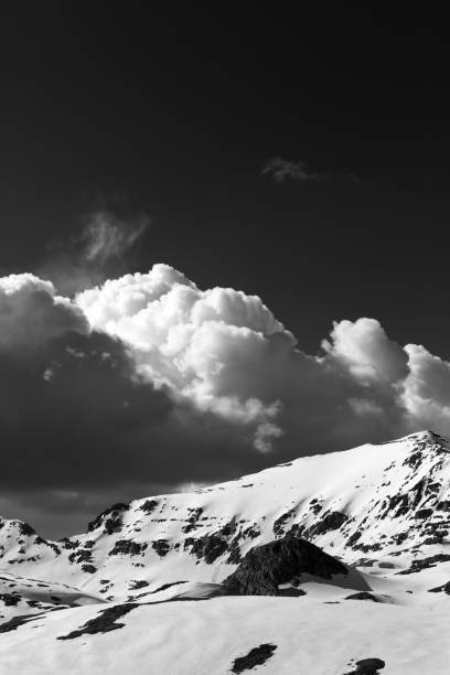 Black and white snowy mountains and sky with clouds. Turkey, Central Taurus Mountains, Aladaglar (Anti-Taurus) plateau Edigel (Yedi Goller)