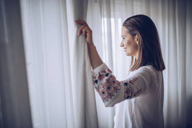 istock Woman looking through the window 938867690