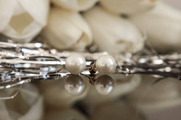 istock White pearl earrings on tulip background 938871114