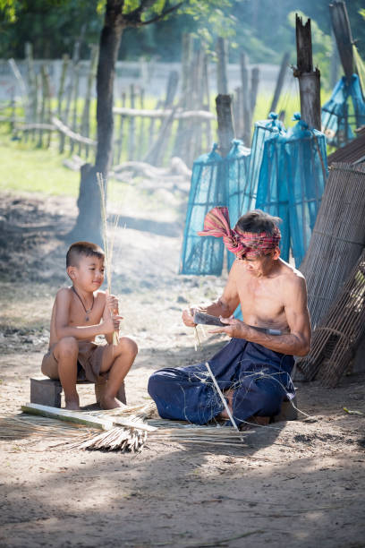 istock Shirtless Boy Sitting By Craftsperson On Ground 938871514
