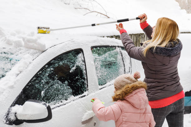 istock Family removing snow from their car together 938875978