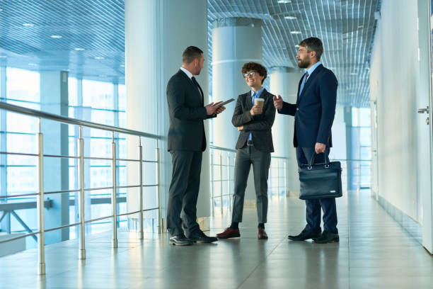istock Modern business colleagues talking in corridor 938876376