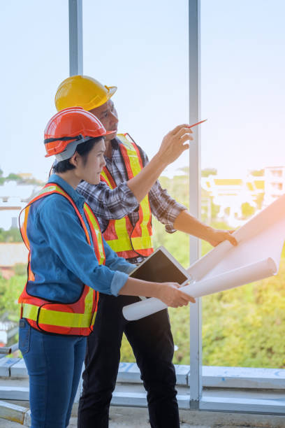 istock Coworkers Holding Blueprint While Working At Construction Site 938877374