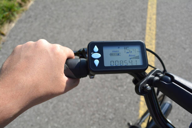 istock Man hand on the electric bicycle handle with computer. Healthy life style concept. Hand holding e bike handlebar with ebike scooter display. 938885972