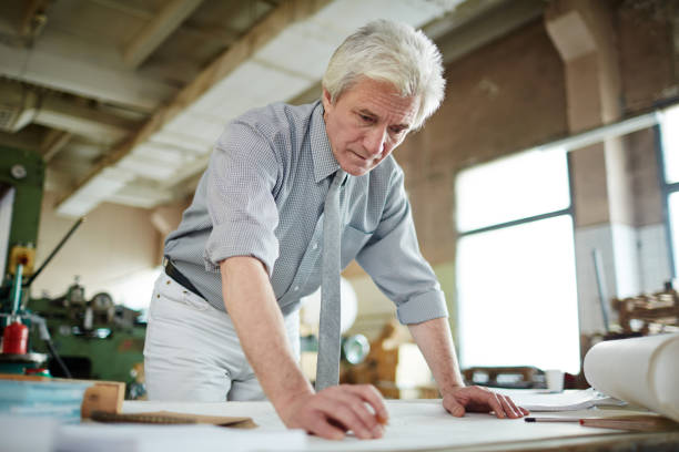 istock Busy senior engineer elaborating design in factory shop 938887062