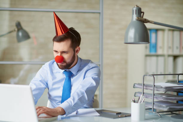 giorno degli sciocchi in ufficio - clown laptop bizarre men foto e immagini stock
