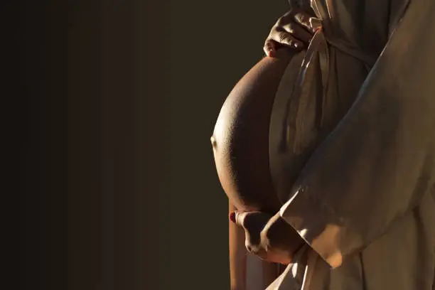 Photo of Beautifil Silhouette of a pregnant woman with highlight on belly