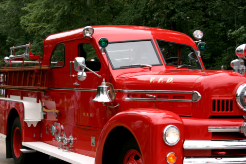 Antique red firetruck in a parade.