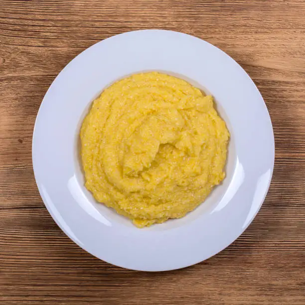 Photo of Brazilian corn porridge in white plate, close up