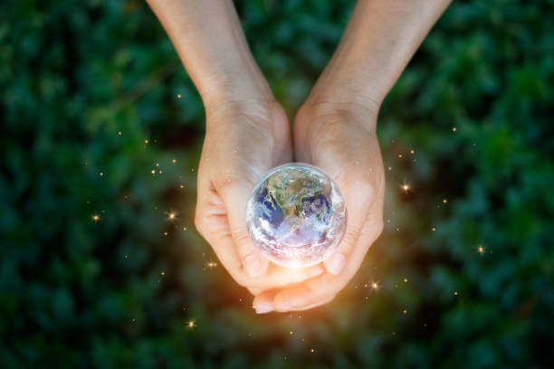 earth day, saving energy concept, hand holding earth against nature on green leaf top view in the park. save the earth and ecological, element of this image furnished by nasa. - earth globe human hand symbols of peace imagens e fotografias de stock