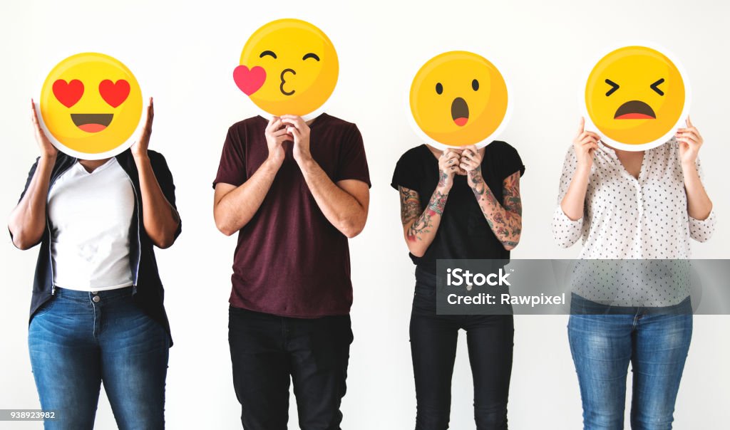 Diverse people holding emoticon Emoticon Stock Photo