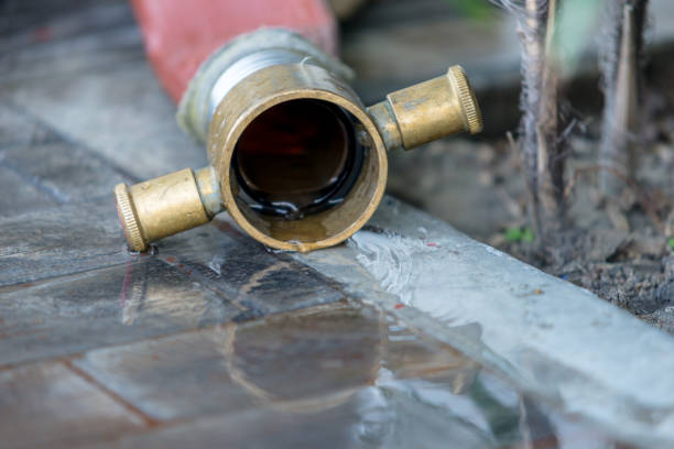 istock water flows out of Fire hose with reflection in water on the rough ground after use 938924188