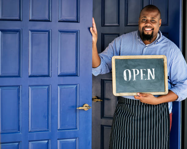 istock A cheerful small business owner with open sign 938927116