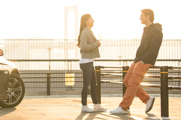 The couple is talking at sunset. A couple seems to be on good side with a conversation at the beach and at sunset. futuristic couple stock pictures, royalty-free photos & images