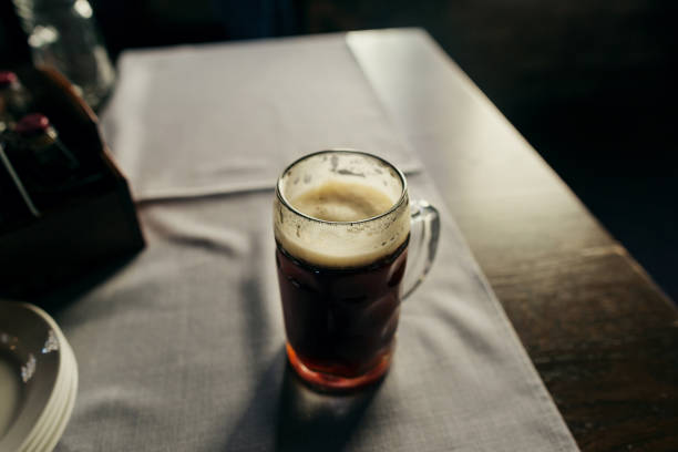 istock Glass of fresh dark beer close up on table 938938852