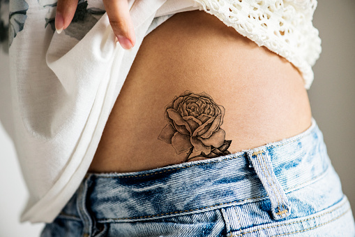 Closeup del tatuaje cadera más baja de una mujer photo