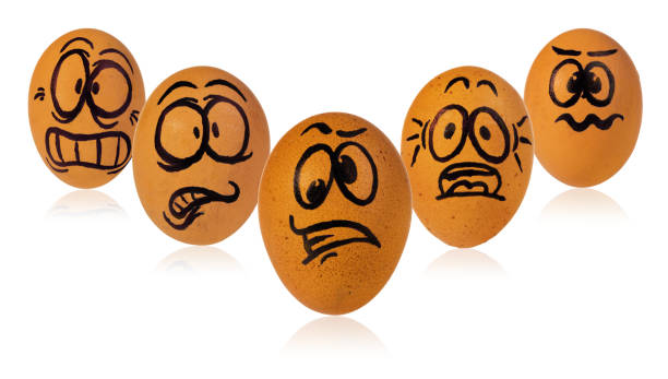 istock Easter eggs, painted in a terrified cartoon funny faces of a guys. Decorated scared eggs in a natural yellow color. 938944680