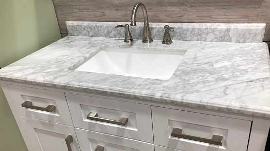 marble countertop on bathroom white cabinet with white rectangular under mount sink and chrome faucet