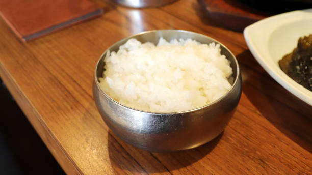 A bowl of white rice in a stainless steel bowl. stock photo