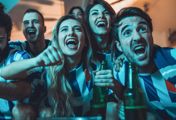 istock Joyful fans screaming while watching soccer match on TV at home. 938966080