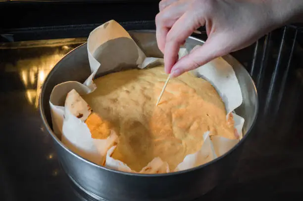 Check a cake for doneness by using the toothpick test while Cookie cake is baking in the oven, with a high temperature in accordance with the recipe