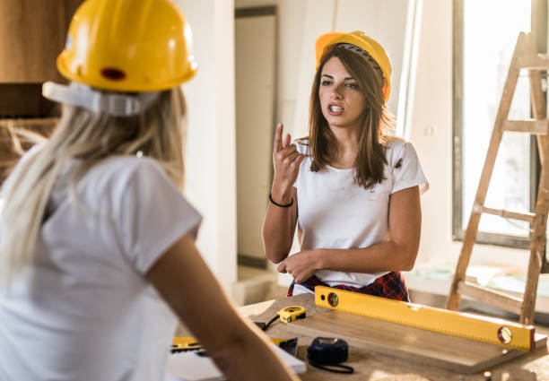 istock Displeased female worker talking to her colleague at construction site. 938972604