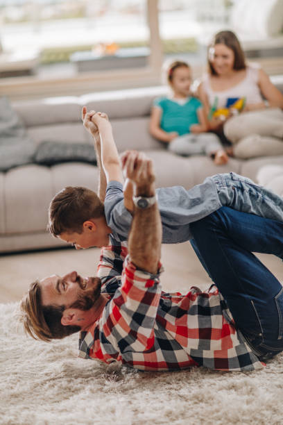 istock Playful father and son having fun on the carpet at home. 938972796