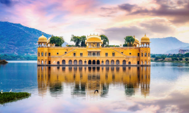 Jal Mahal water palace Jaipur Rajasthan with landscape at sunset. Jal Mahal water palace Jaipur Rajasthan at sunset with vibrant moody sky rajasthan photos stock pictures, royalty-free photos & images